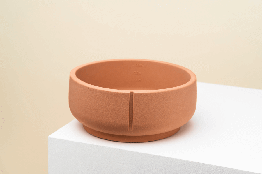 Een handgemaakte Pino Classic Feeder Foxy Terra bowl van duurzaam polysand, geschikt voor binnen en buiten. Met maatstrepen voor voedselhoeveelheid en unieke marmer-print.