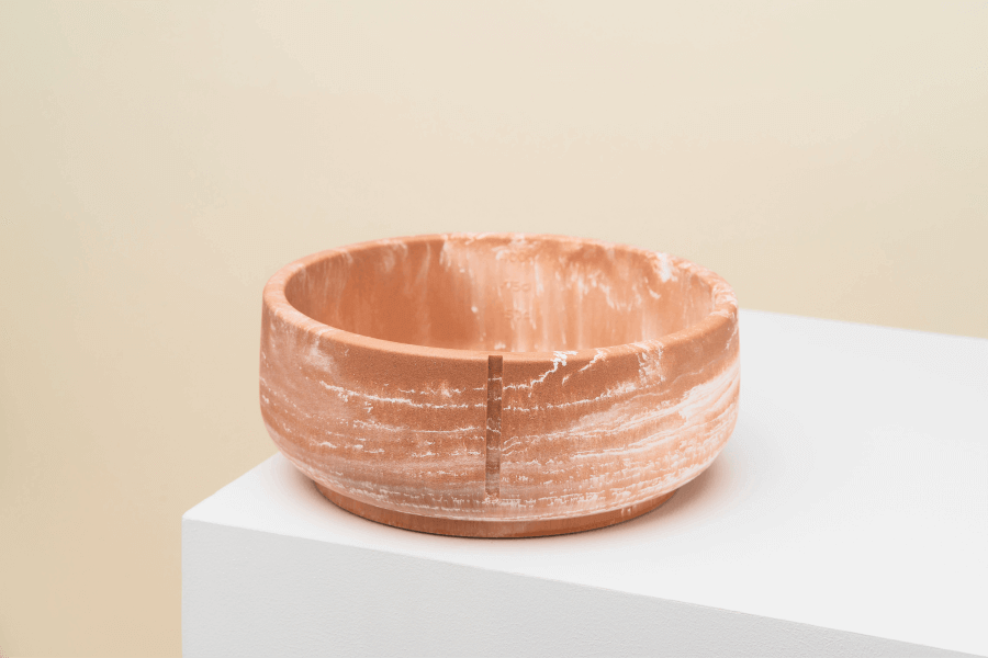 Een handgemaakte Pino Classic Feeder Foxy Terra Marble bowl voor huisdieren, gemaakt van duurzaam polysand met maatstrepen en antislip afwerking.