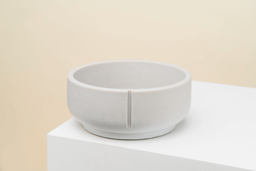 Een handgemaakte Pino Classic Feeder Dolphin Grey bowl van duurzaam polysand, geschikt voor viervoeters van verschillende groottes. Met maatstrepen en antislip afwerking voor gemakkelijk eten en observeren van eetgedrag.